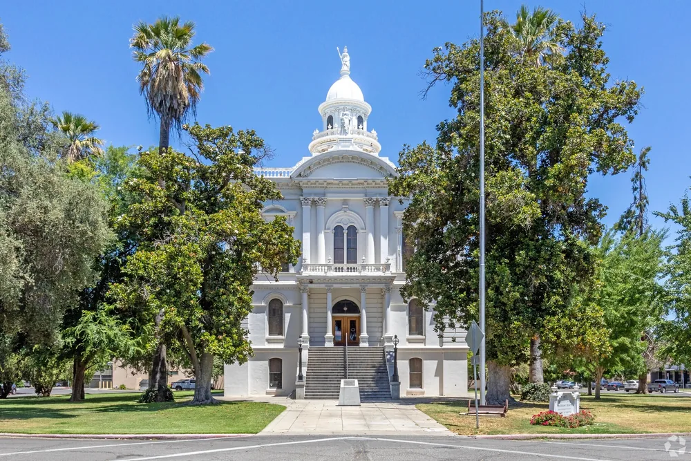 Mature trees and palms surrounding the historic courthouse in Merced, California